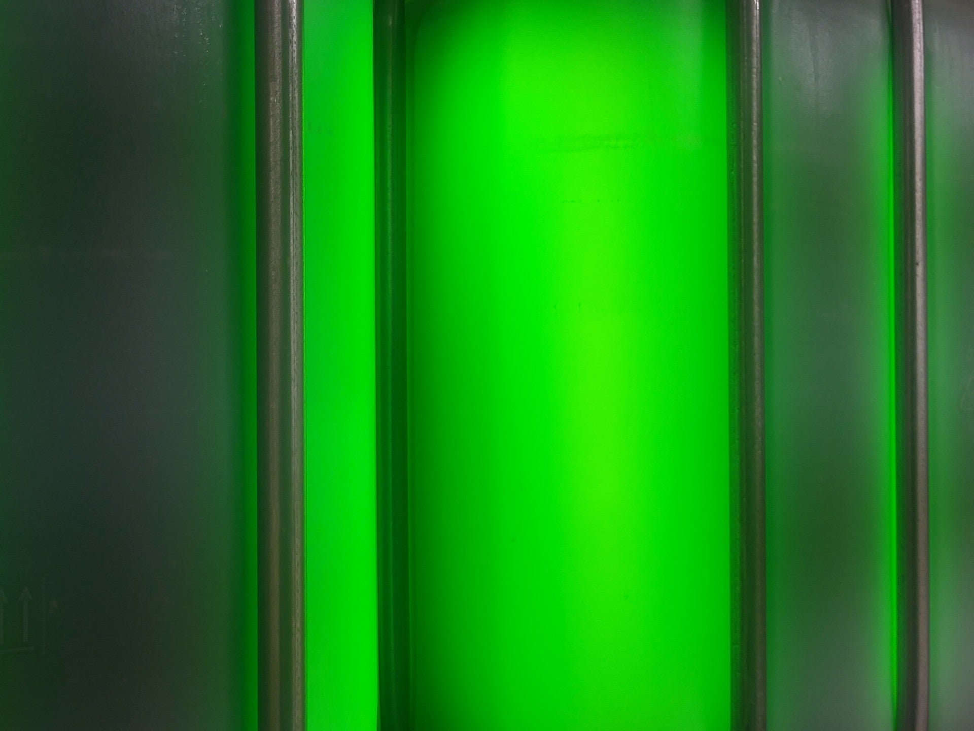 Close-up of fresh spirulina glowing bright green in a bioreactor