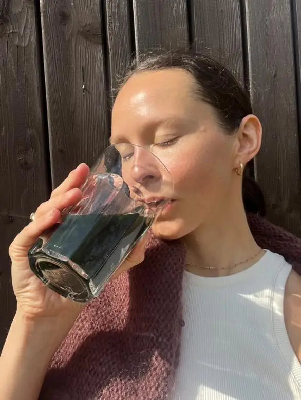 Woman drinking from a clear plastic cup outdoors