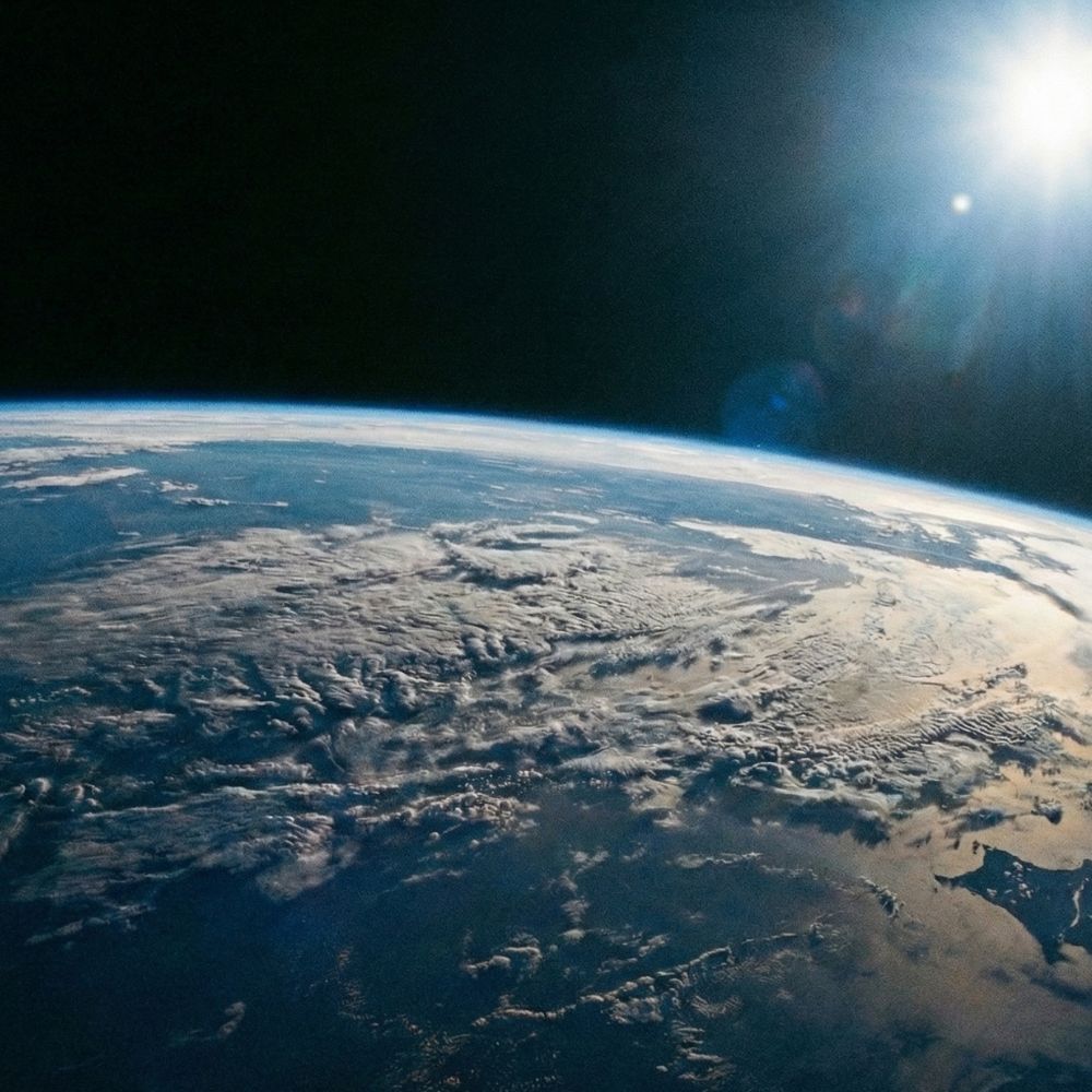 View of Earth from space with a clear sky and sun.
