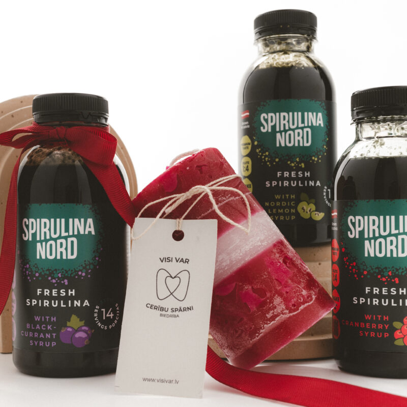 Svinam kopā 3 spirulīnas sīrupi un svece Latvijas karoga krāsās